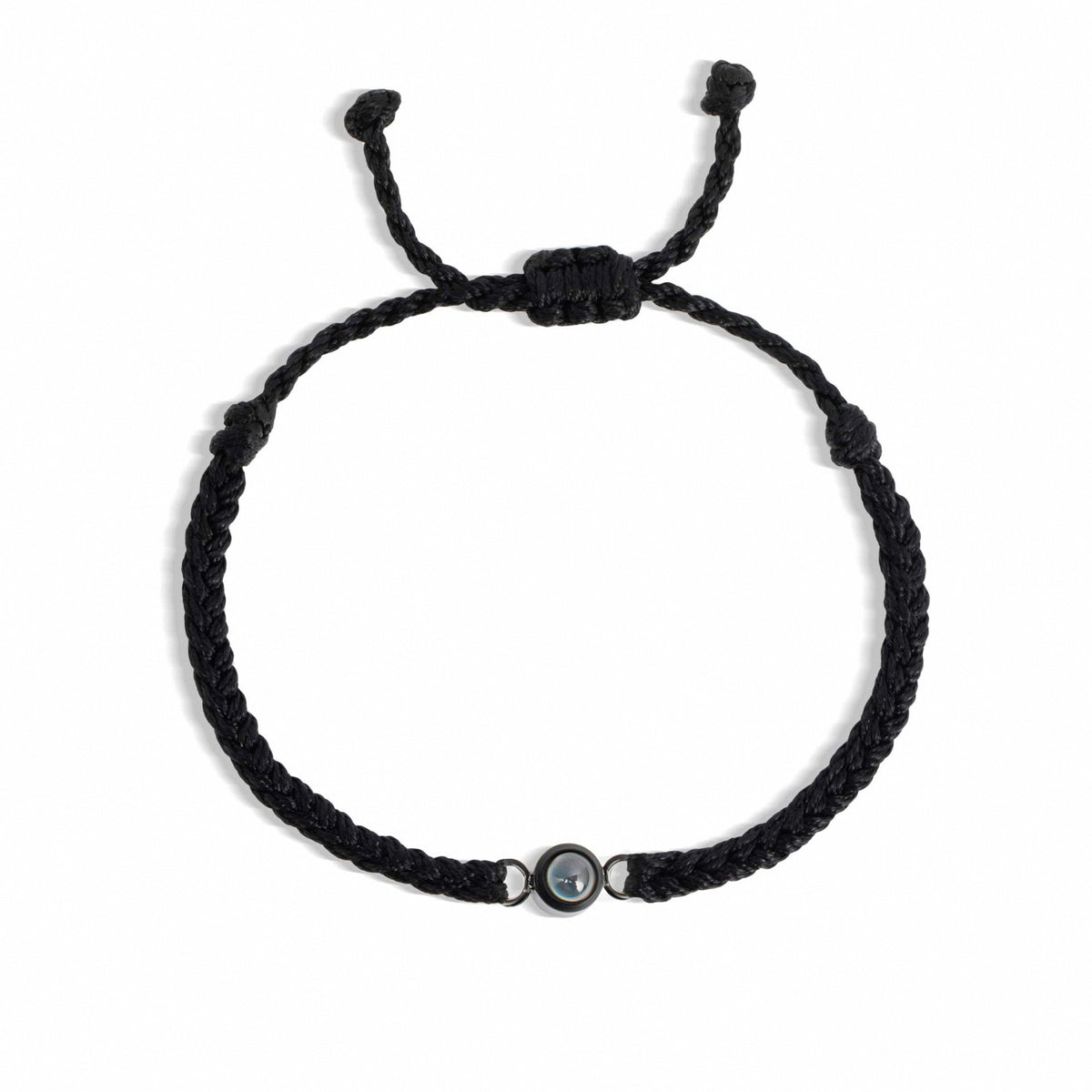 Black braided bracelet with a small round bead on a white background