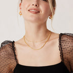 Layered gold necklaces shown on model for stacking jewellery style inspiration