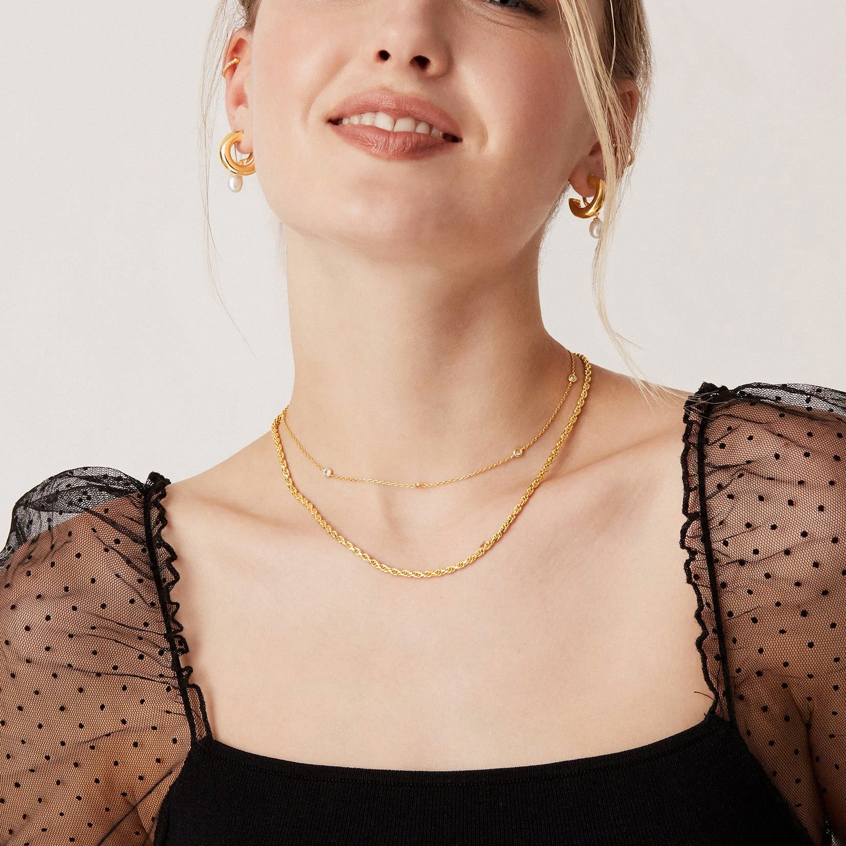 Layered gold necklaces shown on model for stacking jewellery style inspiration