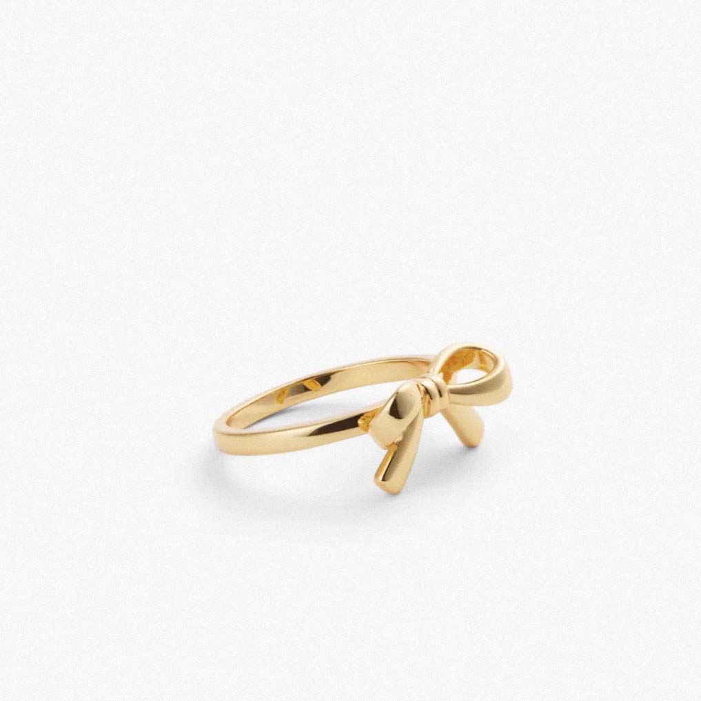 gold plated bow ring on white background