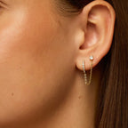 Gold dual chain hoop earrings worn on ear