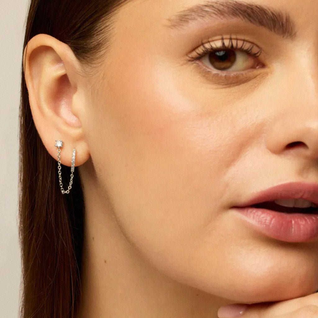 Silver dual chain hoop earrings worn on ear