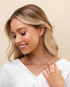 Everyday gold solitaire pendant necklace worn by female model in white top