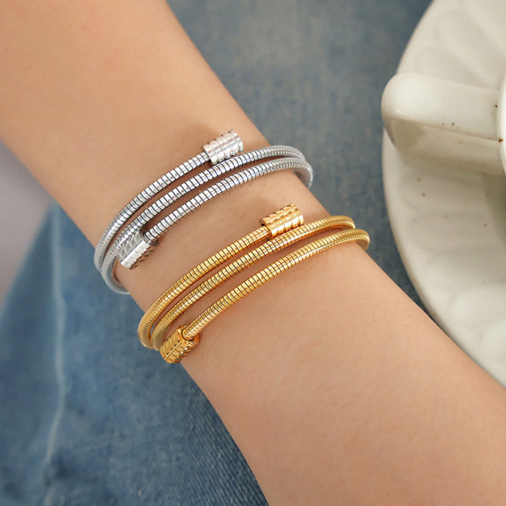 Stacked gold and silver coil bangles for modern layered style