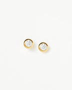 Detailed macro shot of gold bezel stud earrings showing crystal clarity