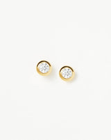 Detailed macro shot of gold bezel stud earrings showing crystal clarity