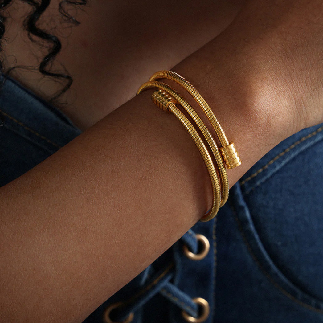 Sleek gold coil bracelet styled with casual outfit