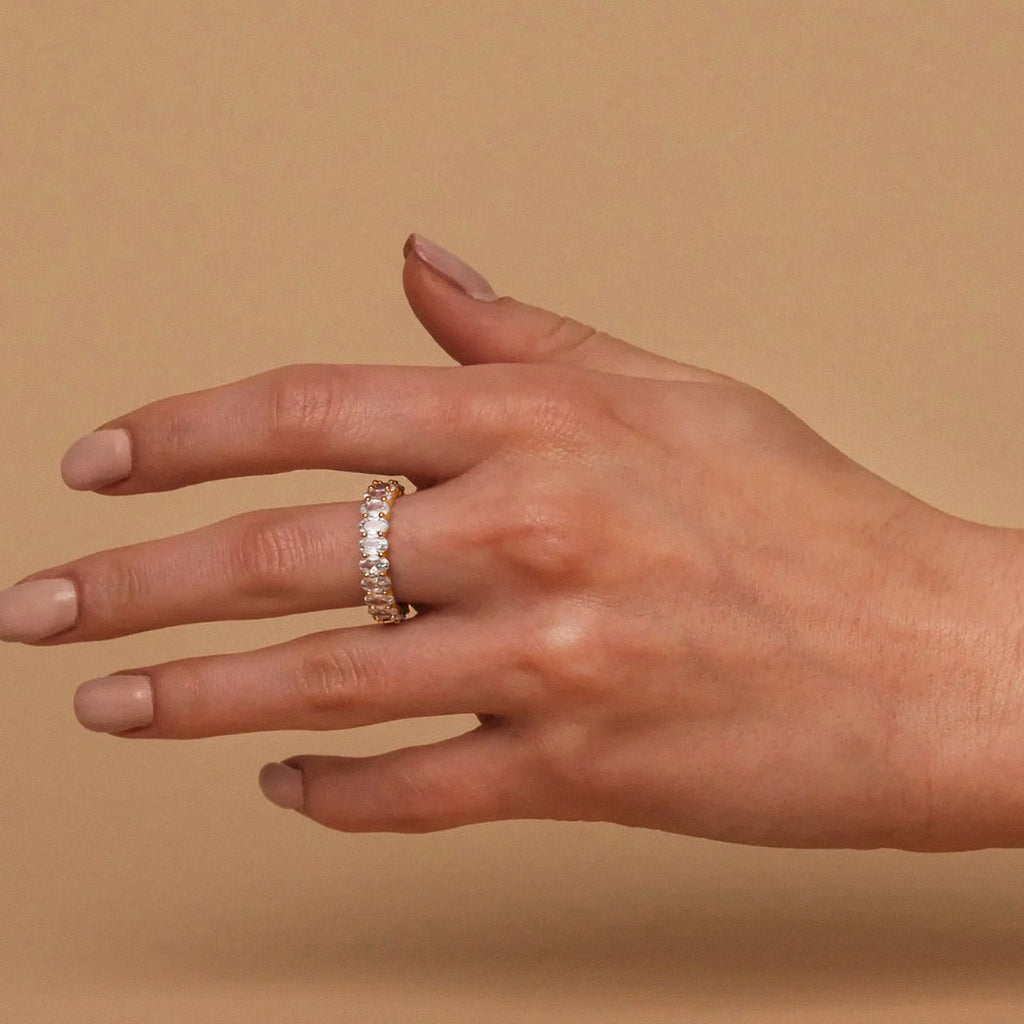 Gold-plated oval zirconia eternity ring seen on extended hand
