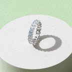 Gold-plated oval zirconia eternity ring displayed on minimal pedestal