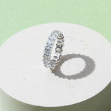 Gold-plated oval zirconia eternity ring displayed on minimal pedestal