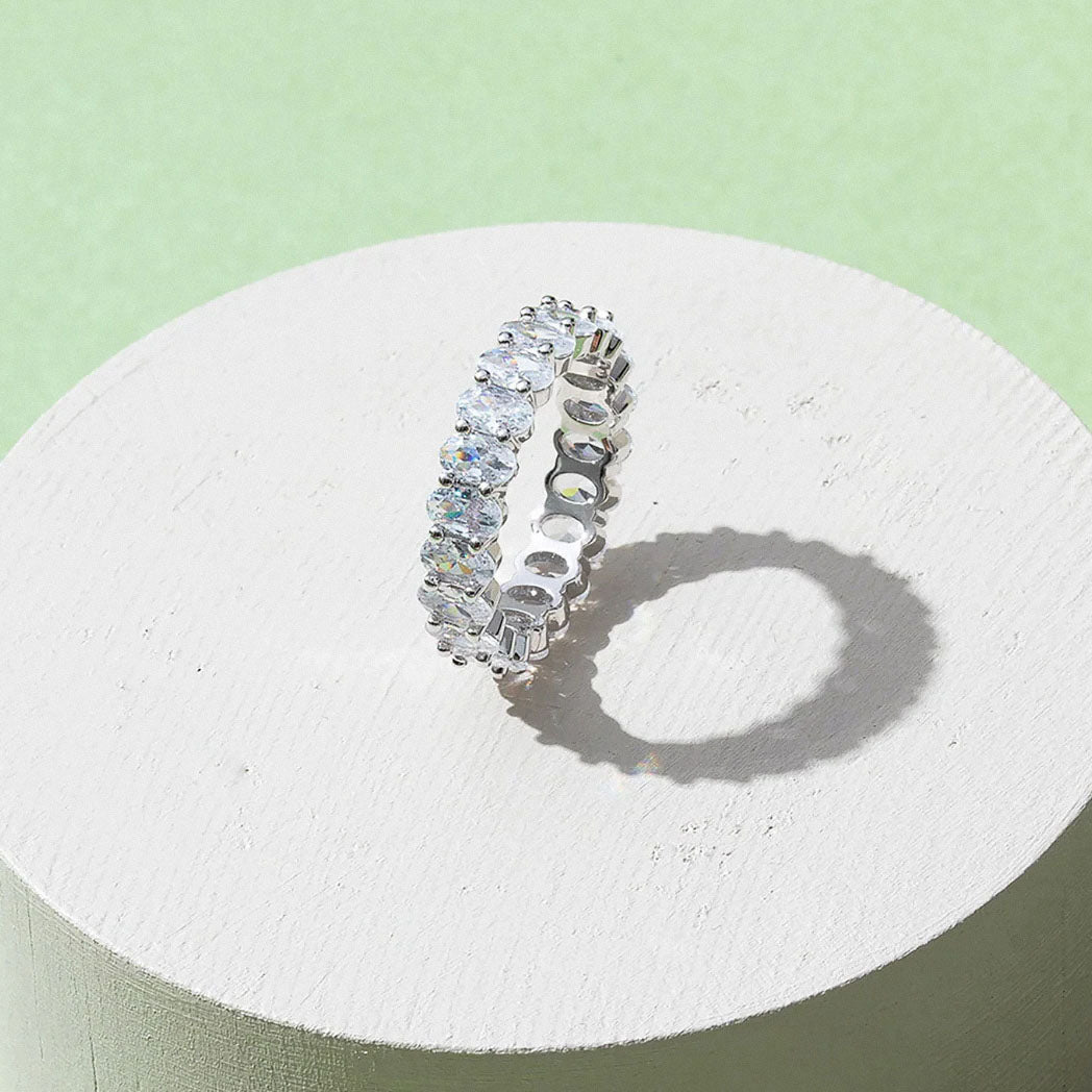 Gold-plated oval zirconia eternity ring displayed on minimal pedestal