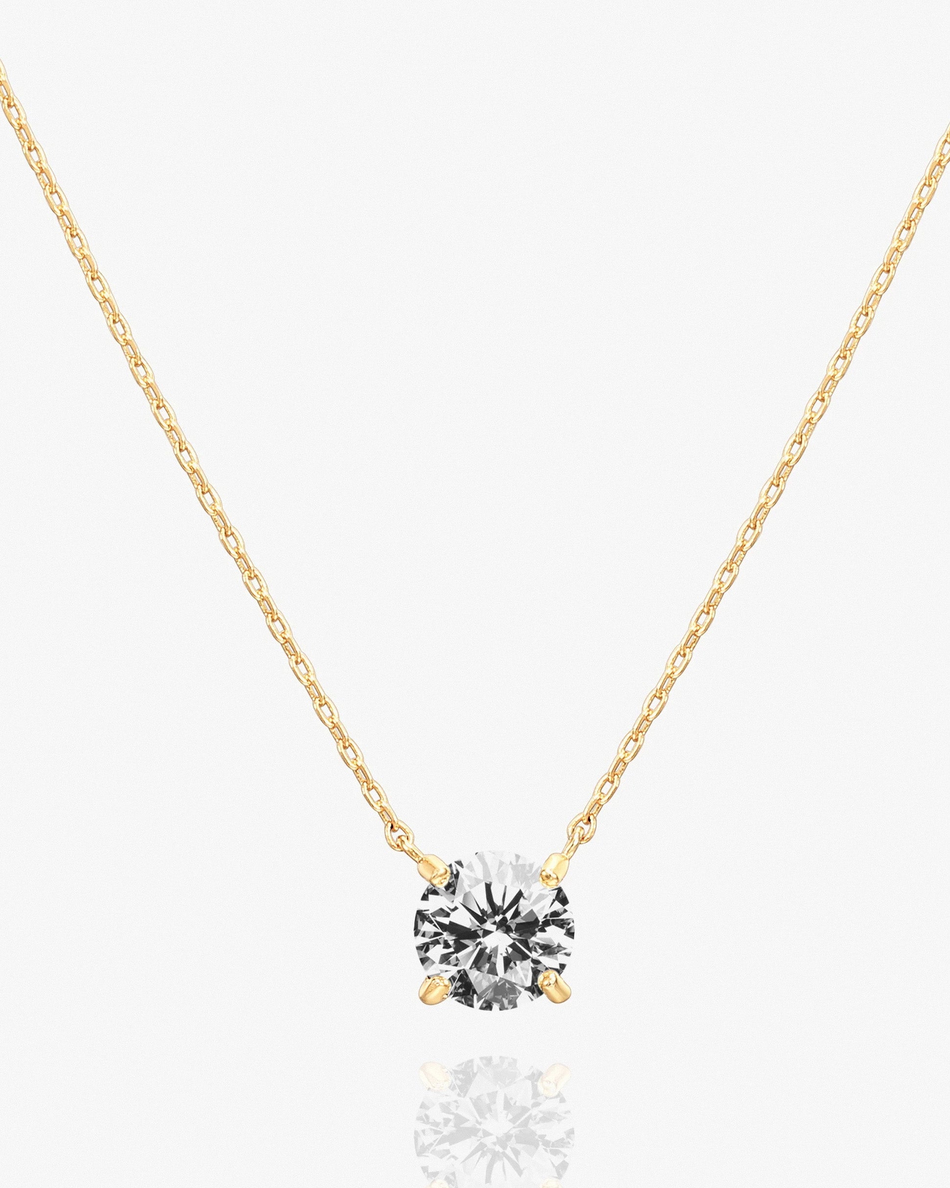 Gold solitaire pendant necklace with cubic zirconia on delicate chain.