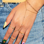 Close-up of gold hand chain bracelet with crystal accents on hand.