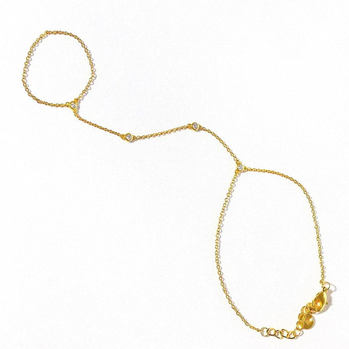 Gold hand chain bracelet with crystal accents displayed flat on white background.