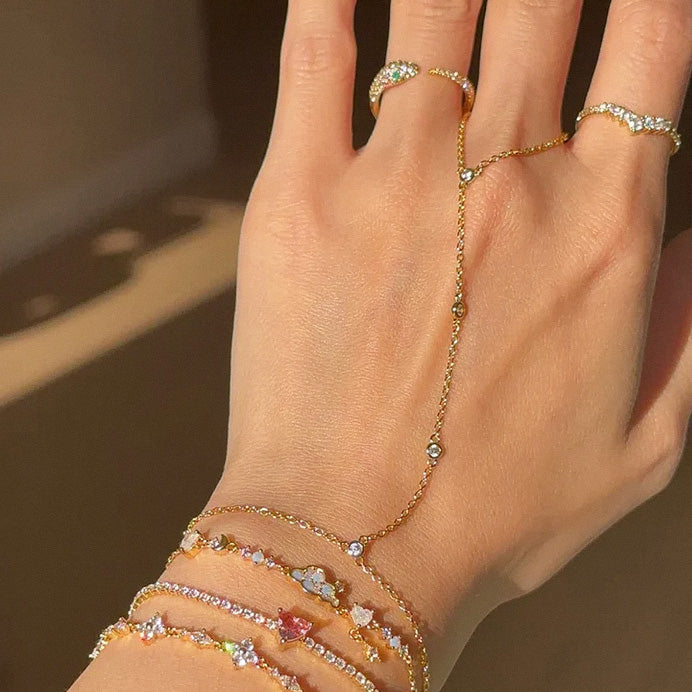 Layered bracelet styling featuring gold crystal hand chain bracelet