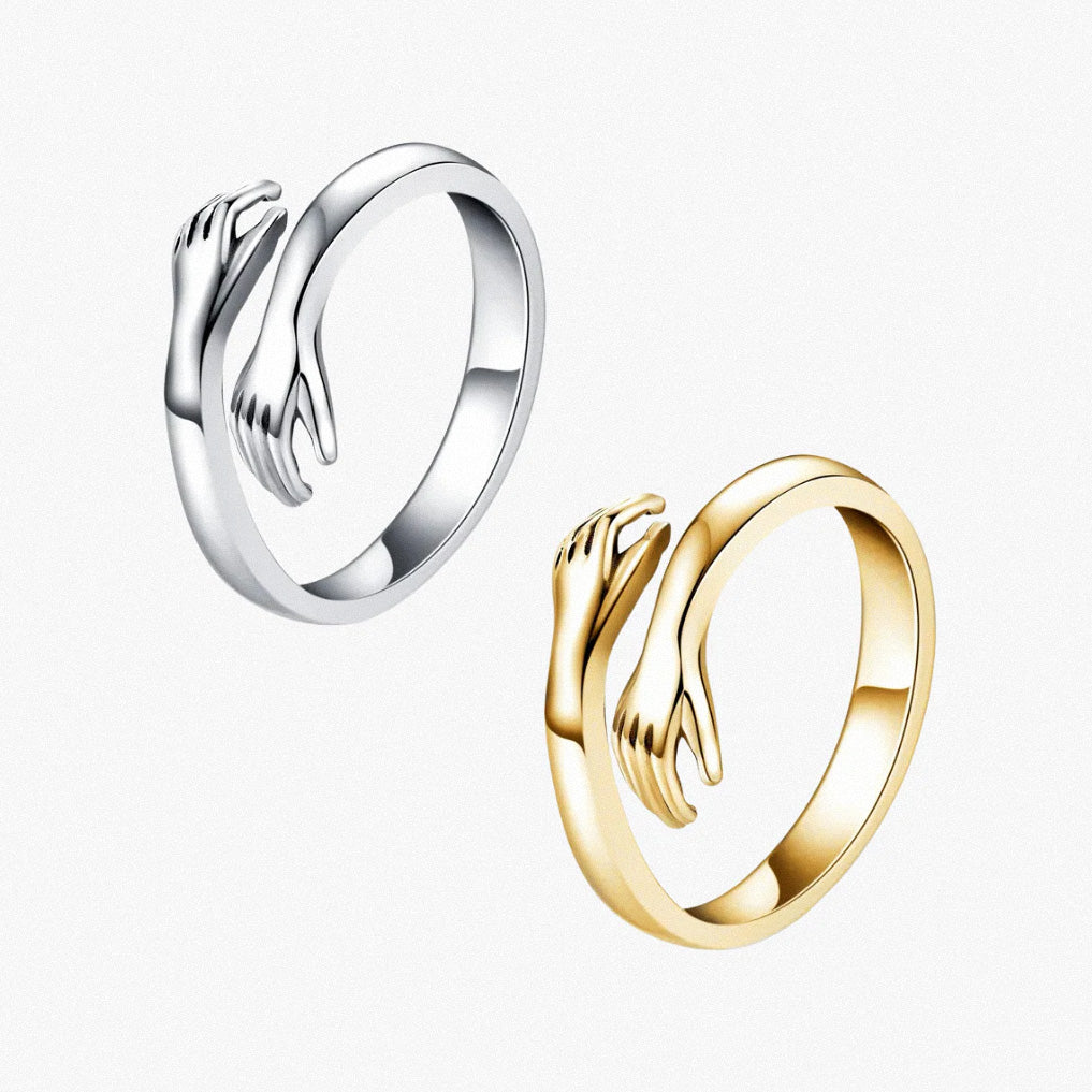 Silver and gold hug rings with polished open-band hand design