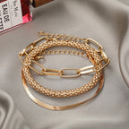 Gold multi-layer bracelet set displayed on fabric
