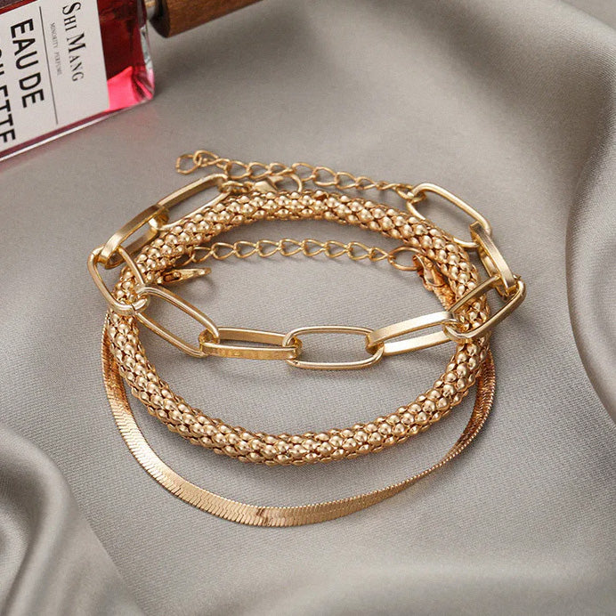 Gold multi-layer bracelet set displayed on fabric