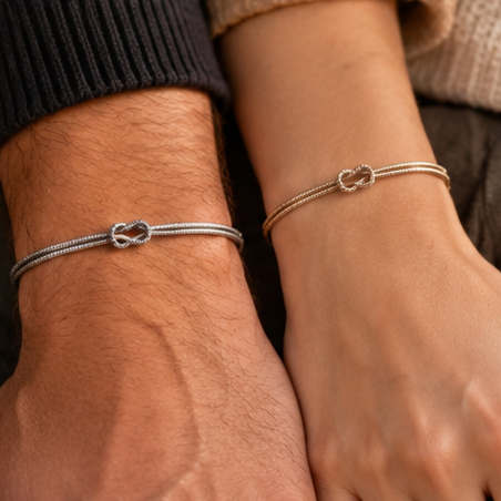 Two wrists side by side wearing matching silver Love Knot Bracelets