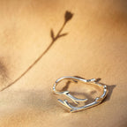 Nature-inspired sterling silver branch ring displayed on fabric