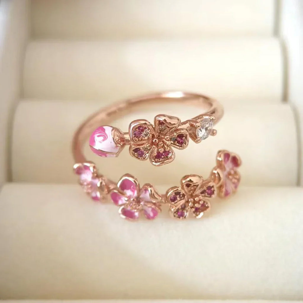 Detailed view of pink blossom branch ring with enamel petals and stones
