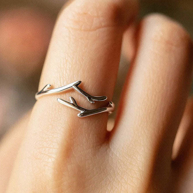 Adjustable silver branch-inspired ring worn on finger
