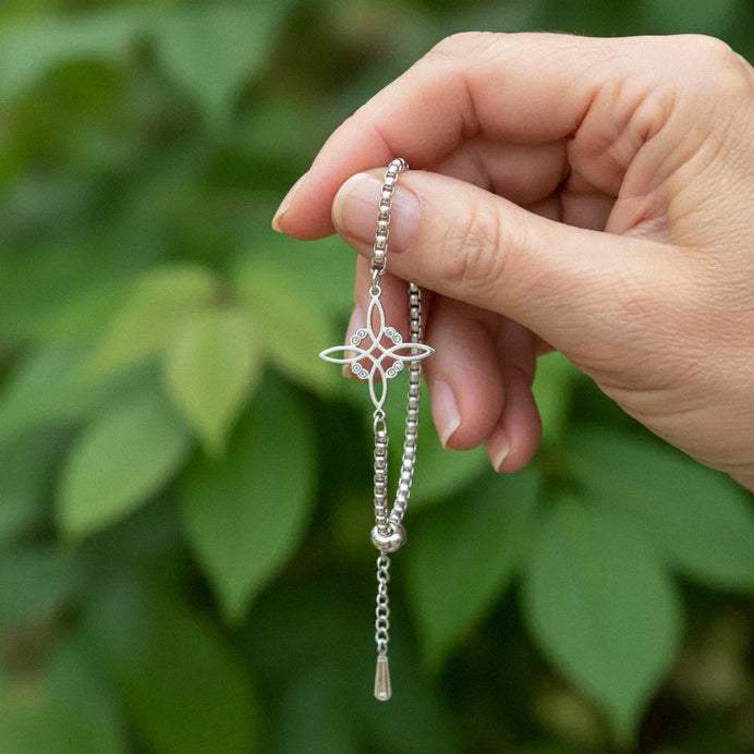 Sterling silver floral charm bracelet being held to show design
