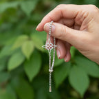Sterling silver floral charm bracelet being held to show design