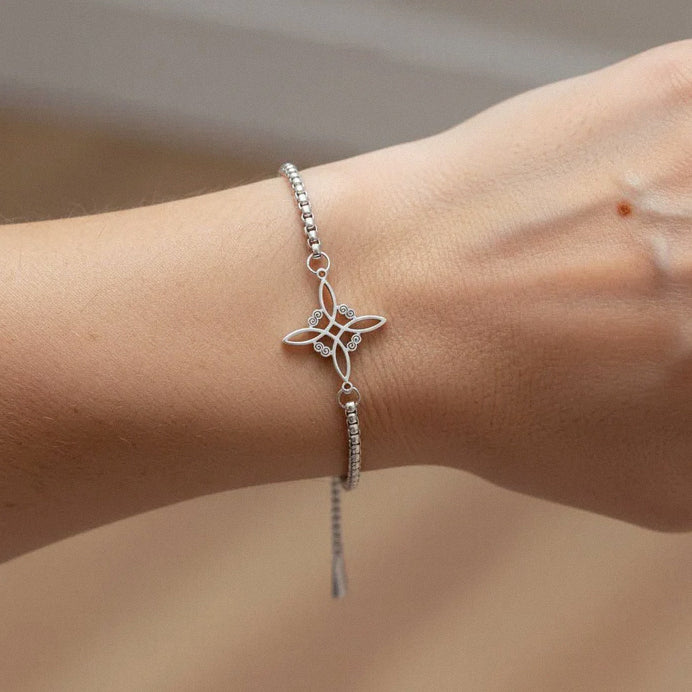 Elegant sterling silver floral bracelet worn on wrist with adjustable chain