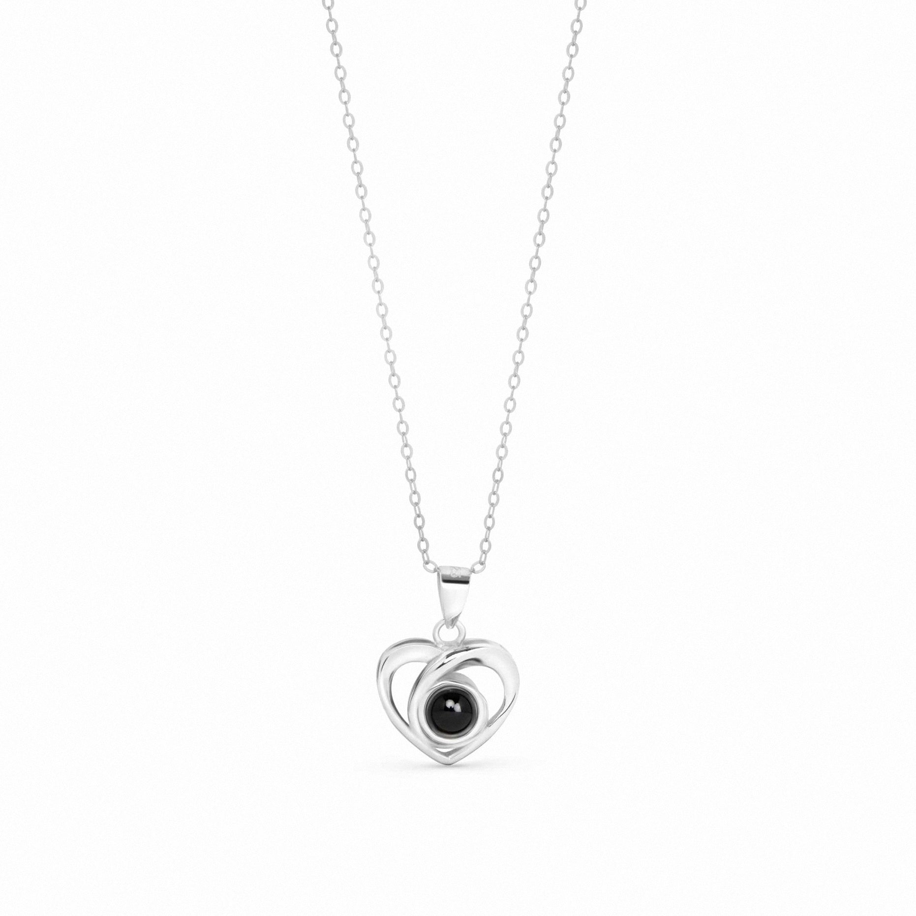 A silver necklace featuring a double-heart pendant with a central black oval stone, suspended on a delicate silver chain against a plain white background.