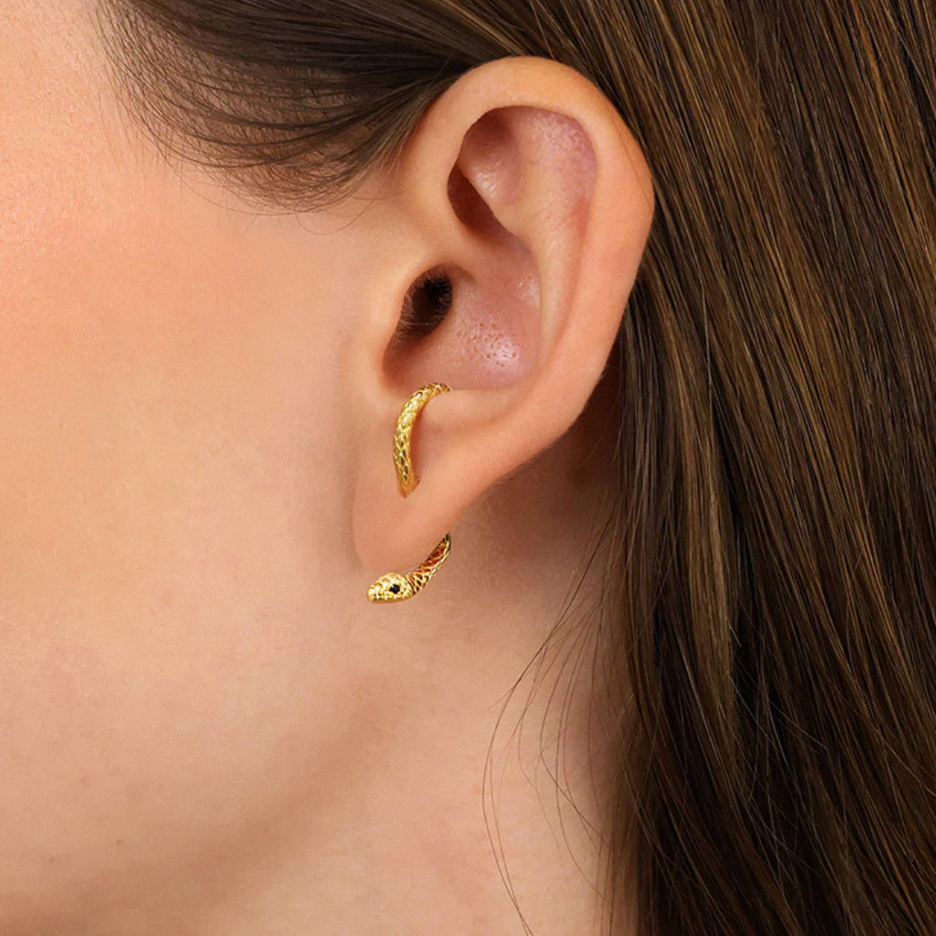Gold snake hoop earring worn on ear