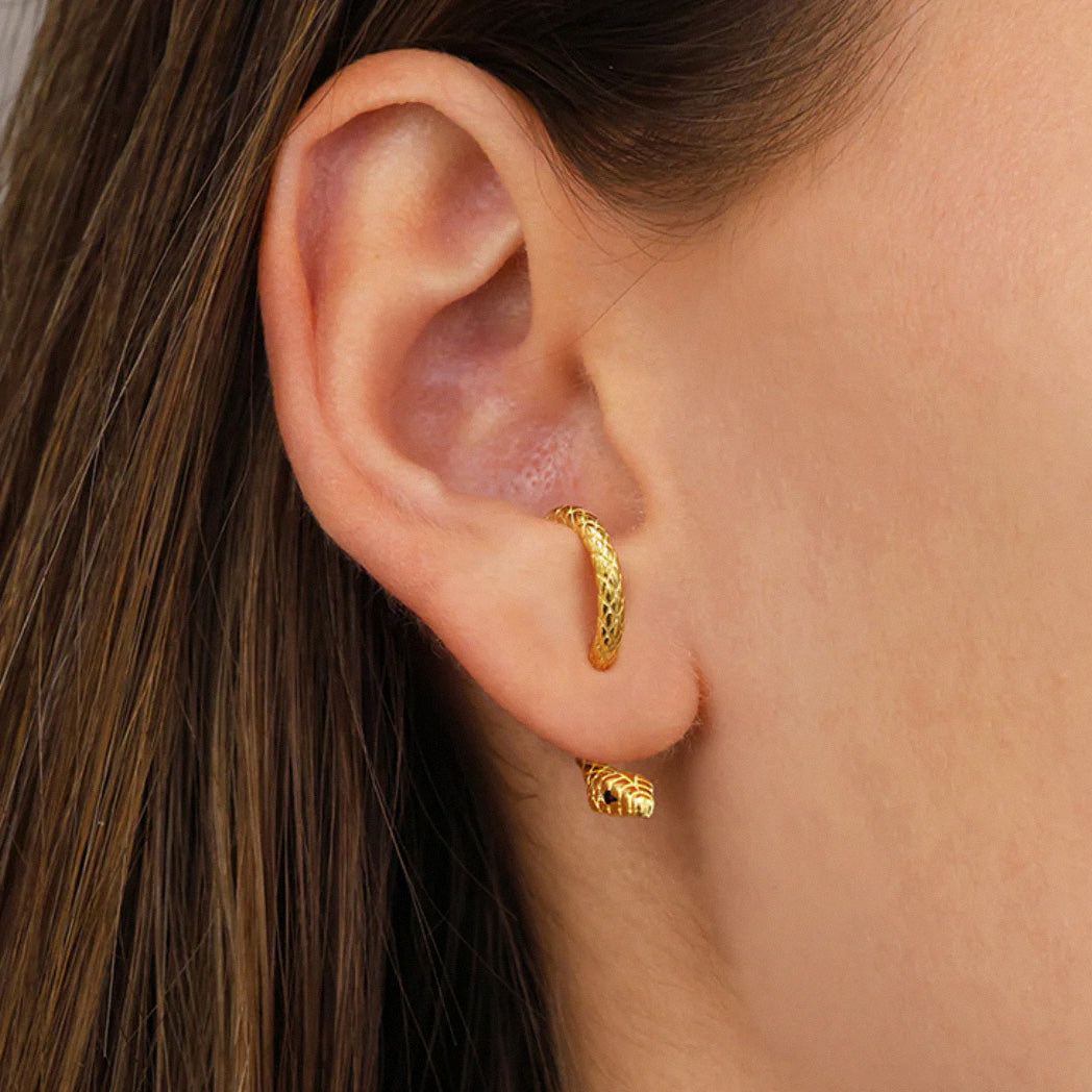 Close-up of gold snake hoop earring