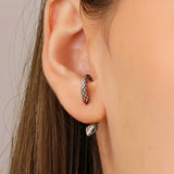 Model wearing silver snake hoop earrings