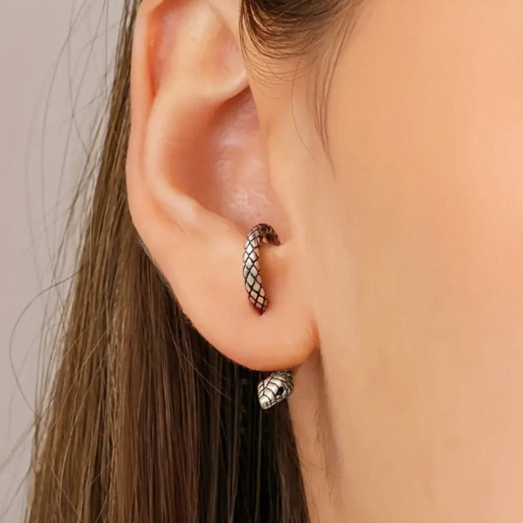 Model wearing silver snake hoop earrings