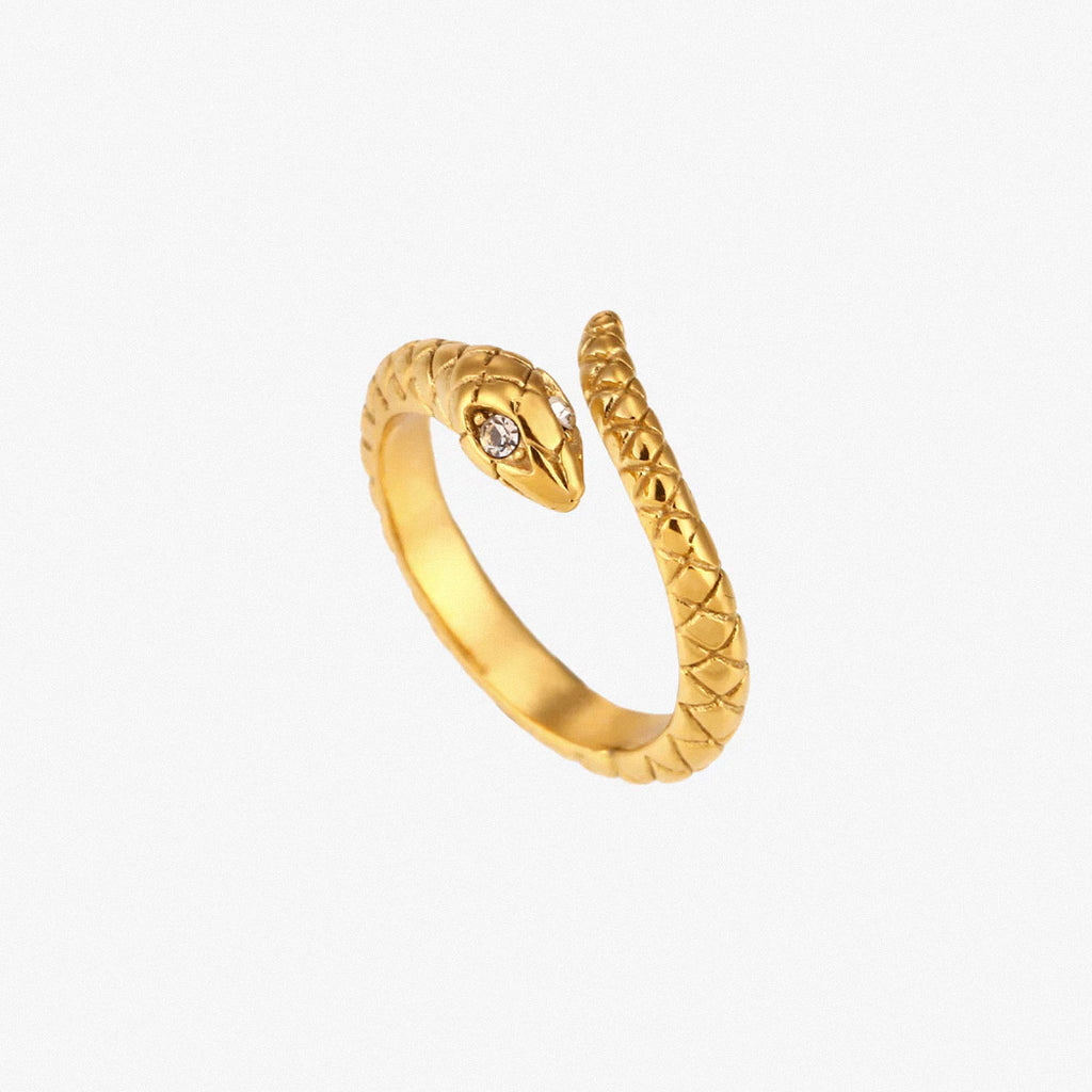 Gold textured snake ring with crystal detail on white background
