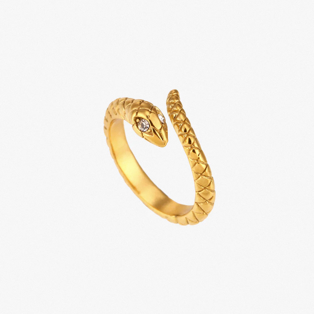 Gold textured snake ring with crystal detail on white background