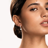 Minimalist gold huggie earrings with crystal star pendant on model