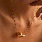 Gold sculpted teardrop necklace close-up on model